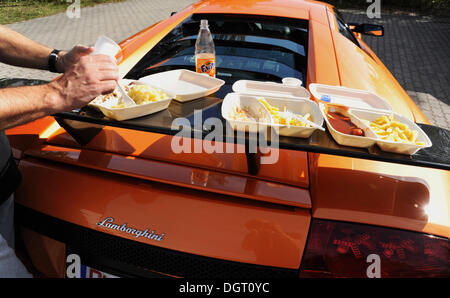 Kotflügel hinten von einem IMSA Lamborghini Murcielago GTR, verwandelte sich in einen Tisch für eine Mahlzeit mit Bratwurst und Pommes frites Stockfoto
