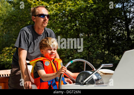 Vater und Sohn an der Spitze von einem Hausboot auf dem Canal du Midi in der Nähe von Bram, Bram - Aude, Region Languedoc-Roussillon, Frankreich Stockfoto