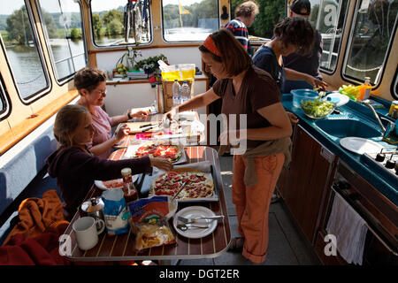 Gemeinsame Vorbereitung des Mittagessens in der Lounge eine Pénichette Hausboot auf dem Fluss Saône, Ormoy, Vesoul, Region Franche-Comté Stockfoto