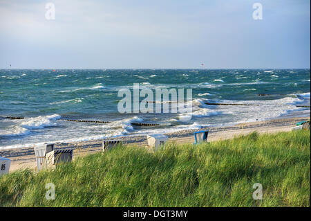 Liegestühle am Strand mit einer rauen Ostsee in der Nähe von Ahrenshoop, stürmisches Wetter, Dünen mit Dünengebieten Grass oder Strandhafer Stockfoto