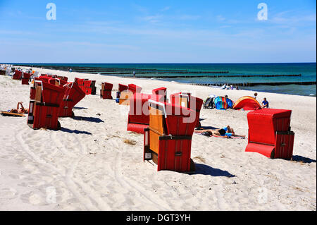 Rot überdachten Strand Korbsessel auf den Strand von Ahrenshoop, Buhnen in der Ostsee auf der Rückseite, Ahrenshoop, Darß Stockfoto