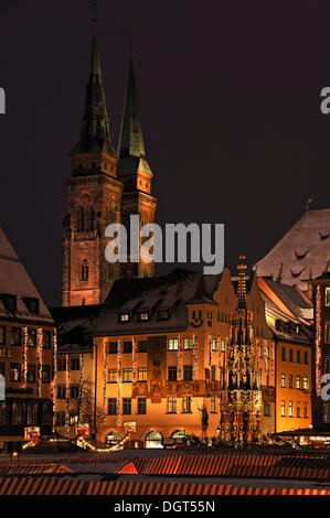 Beleuchtete Nürnberger Weihnachtsmarkt, Schoene Brunnen oder schönen Brunnen und St. Sebald Kirche auf der Rückseite, Hauptmarkt Stockfoto