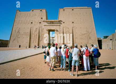 Eine Gruppe von Touristen mit ihrem Führer am Eingang Pylonen der Tempel des Horus in Edfu, an den Ufern des Nil, Ägypten Stockfoto