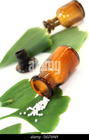 Ginkgo Blätter mit Apotheker Flasche vor weißem Hintergrund Stockfoto