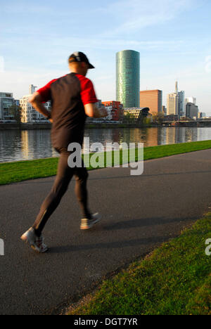 Jogger Joggen entlang des Flusses, Theodor Stern Kai, Westhafen Tower im Quartier Gutleutviertel, Skyline von der Büroviertel Stockfoto