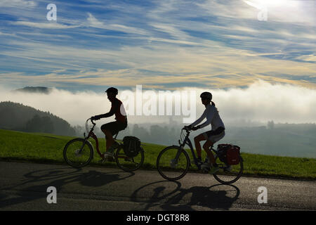 Radfahrer fahren Elektrofahrräder auf Tannberg Berg, Koestendorf, Waller See, Salzburger Seenland, Salzburg, Österreich Stockfoto