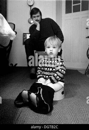 Vater mit Baby sitzen auf dem Töpfchen, Leipzig, DDR, historische Foto ca. 1974 Stockfoto