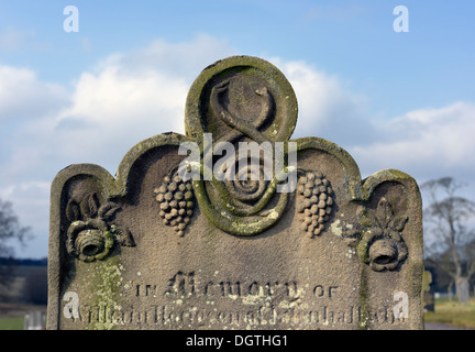 Grabstein mit Trauben und Rosen-Design. Kirche des Heiligen Cuthbert. Edenhall, Cumbria, England, Vereinigtes Königreich, Europa. Stockfoto