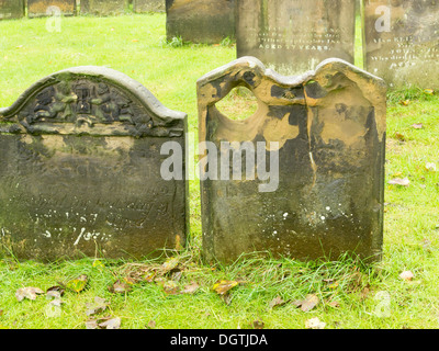 Ein Grabstein so getragen, dass die Inschrift in ein Loch wie ein zwinkernde Auge geformt erodiert Stockfoto