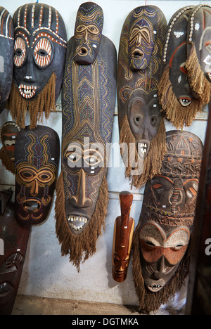 Afrikanische Stammes-Masken mit Knochen Zähne im touristischen Ladengeschäft Kenia Mombasa Stockfoto