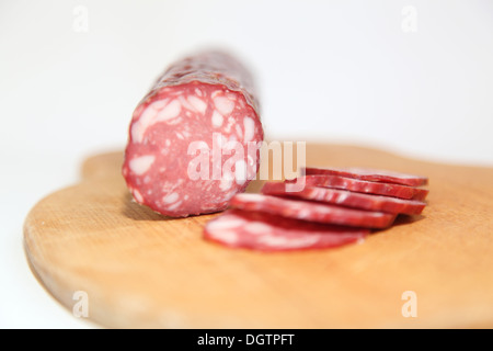Salami auf dem Brett in Stücke schneiden. Stockfoto