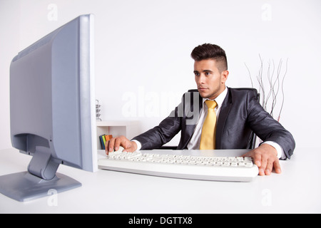 Geschäftsmann in seinem Büro mit seinem Desktop-computer Stockfoto