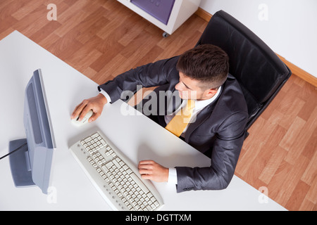 Geschäftsmann in seinem Büro mit seinem Desktop-computer Stockfoto