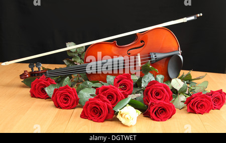 Violine und Rosen auf schwarzem Hintergrund Stockfoto
