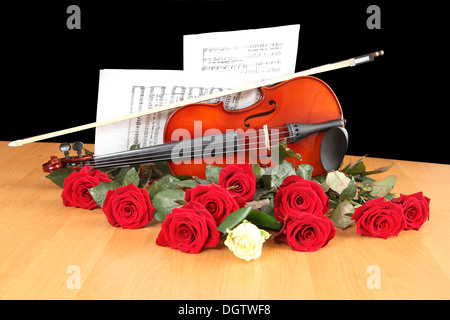 rote und weiße Rosen auf einem Blatt mit Notizen Stockfoto