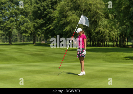 Golfer, die Fahne im Loch zurück Stockfoto