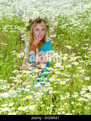 junge Frau in einem Kranz von Wildblumen Stockfoto