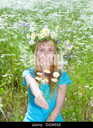 junge Frau in einem Kranz von Wildblumen Stockfoto