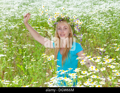 junge Frau in einem Kranz von Wildblumen Stockfoto