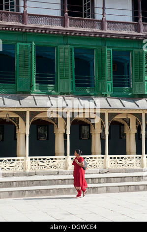 Frau trägt einen roten Sari vor einem viktorianischen Stil bauen, Platz im Königspalast Hanuman Dhoka, Kathmandu Stockfoto