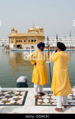 Sikhism, zwei Sikh Wächter hält eine Lanze tragen Turbane und Bärte im Gespräch mit einander, Heiligtum Stockfoto