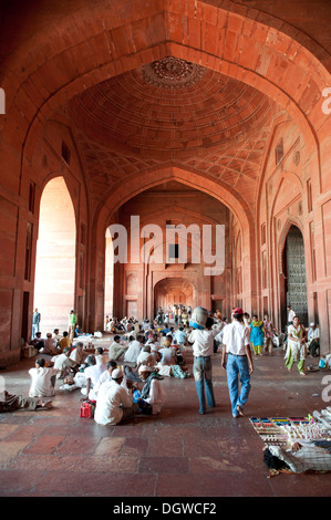 Mogul-Architektur, Moschee, hohe Decke, Halle, Gläubigen, eine Menge Leute sitzen auf dem Boden im Buland Darwaza Tor Stockfoto