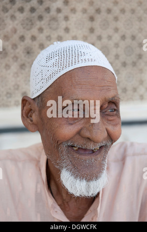 Islam, Porträt, Muslim, Alter Mann mit einem Bart trägt eine Mütze, sitzt vor dem Grab von Scheich Salim Chishti Stockfoto