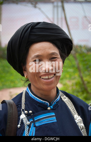 Porträt, Frau der Yi oder Hani ethnische Minderheit trägt eine dunkle Tracht mit einem Turban, Jiangcheng, Pu'er Stadt Stockfoto