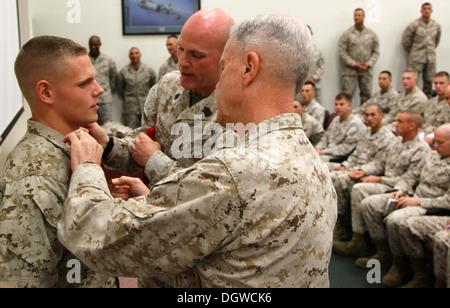 35. Kommandant des Marinekorps, General James F. Amos und die 17. Sergeant-Major der Marine Corps, Sgt. Major Micheal P. Barrett, Förderung von Lance Cpl. Wesleigh M. Beckman, Artillerie-Techniker mit Marine Aviation Logistics Fliegerstaffel 11 (MALS-11) Stockfoto