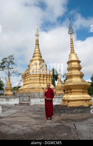 Theravada Buddhismus, goldene Stupa, Mönch in roten Roben, dass Xieng Tung, Muang Sing, Luang Namtha Provinz, Sipsongpanna, Laos Stockfoto