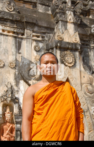 Theravada-Buddhismus, Portrait, Mönch in orangefarbenen Gewändern, alte kunstvolle Tempel, dass Ing hängen Stupa, in Savannakhet, Laos, Südostasien Stockfoto