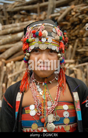 Porträt eines lächelnden Mädchens tragen traditionelle Kleidung, Mütze über Kopf mit bunten Volksgruppe der Akha Eupa Stockfoto