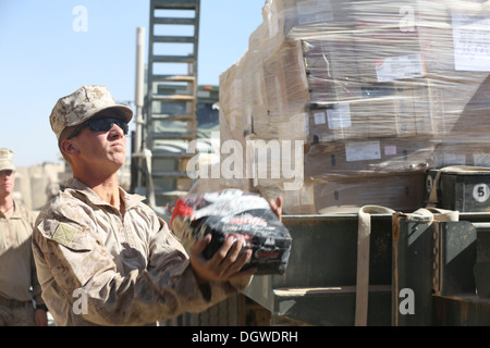 Ein US-Marine mit Charlie Kompanie, 1. Bataillon, 9. Marine Regiment, entlädt Lieferungen aus einem Konvoi im Patrol Base Boldak, Provinz Helmand, Afghanistan, 18. Oktober 2013. Der Konvoi wurde durchgeführt, um PB Boldak Nachschub. Stockfoto