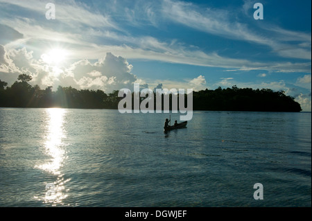 Jungen mit dem Kanu in die Marovo Lagune, bei Gegenlicht, Salomonen Stockfoto