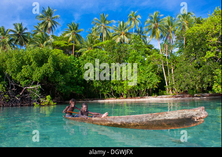 Lokalen Jungs mit dem Kanu in die Marovo Lagune, Marovo Lagune, Western Province, Salomonen Stockfoto