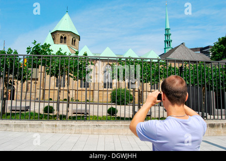 Touristen besuchen das Ruhrgebiet, junger Mann die Bilder von der Essener Dom mit einer digitalen Kamera, Kulturhauptstadt Essen Stockfoto