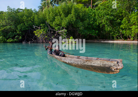 Lokalen Jungs mit dem Kanu in die Marovo Lagune, Marovo Lagune, Western Province, Salomonen Stockfoto