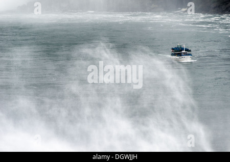 NIAGARA, NY - die Mädchen des Nebels Boot entsteht durch das Spray in Niagara Falls auf dem Niagara River an der Grenze zwischen den Vereinigten Staaten und Kanada. Stockfoto