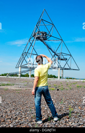 Junger Mann stand vor dem Tetraeder Wahrzeichen, ein Tetraeder, hergestellt aus Stahl, Industriekultur Stockfoto