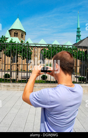 Touristen besuchen das Ruhrgebiet, junger Mann die Bilder von der Essener Dom mit einer digitalen Kamera, Kulturhauptstadt Essen Stockfoto