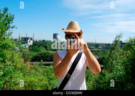 Touristen besuchen das Ruhrgebiet, junger Mann die Industrielandschaft mit einer Digitalkamera zu fotografieren Gasometer Stockfoto