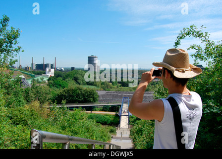 Touristen besuchen das Ruhrgebiet, junger Mann die Industrielandschaft mit einer Digitalkamera zu fotografieren Gasometer Stockfoto