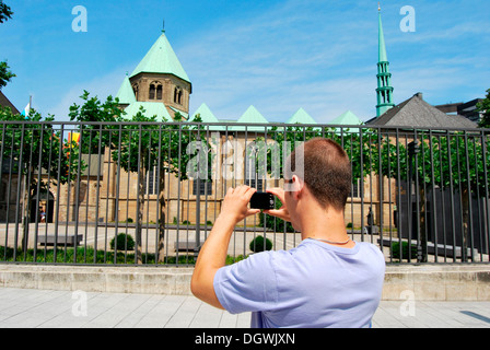 Touristen besuchen das Ruhrgebiet, junger Mann die Bilder von der Essener Dom mit einer digitalen Kamera, Kulturhauptstadt Essen Stockfoto