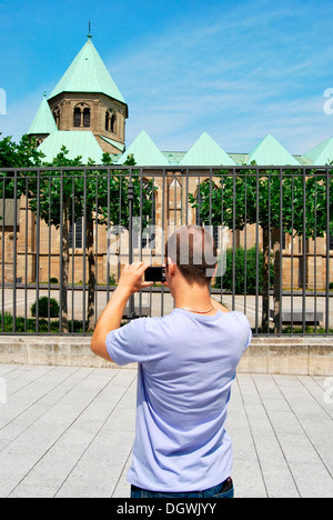 Touristen besuchen das Ruhrgebiet, junger Mann die Bilder von der Essener Dom mit einer digitalen Kamera, Kulturhauptstadt Essen Stockfoto