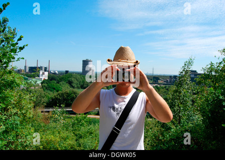 Touristen besuchen das Ruhrgebiet, junger Mann die Industrielandschaft mit einer Digitalkamera zu fotografieren Gasometer Stockfoto