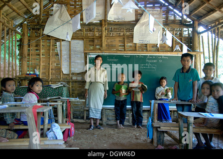 Armut, Lehrer mit einer Klasse in der Schule, vor einer Tafel, Grundschule, Schülerinnen und Schüler der ethnischen Gruppe der Khmu Stockfoto