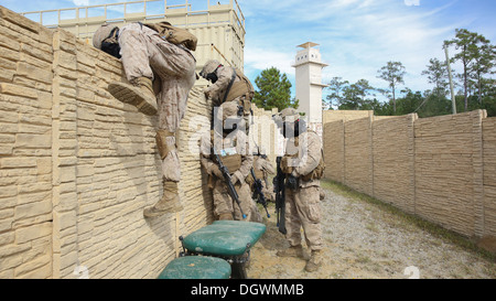 Zwei Marines mit 2. Assault Amphibian Battalion, 2. Marine-Division, Klettern über eine Mauer während angreifende Mobile MOUT Stadt an Bord der Marine Corps Base Camp Lejeune, 20. Oktober 2013. '' 'Amtrackers sind bekannt für Flexibilität und jeder Missi durchführen können Stockfoto