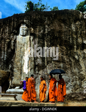 Buduruvagala, Rock von buddhistischen Skulpturen, Mönche stand vor der Deepangkara Buddha-Statue, Buduruvagala, Buduruwagala Stockfoto