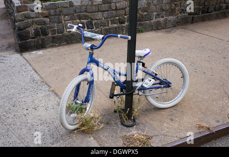 Ein weibliches Kind Fahrrad auf dem Bürgersteig in New York City Stockfoto