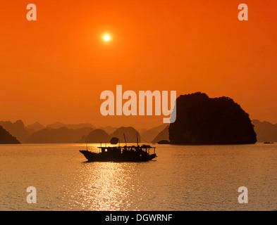 Boot bei Sonnenuntergang, Ha Long Bay, Vinh Ha Long, Kalkfelsen, UNESCO-Weltkulturerbe, Golf von Tonkin, Halong, Nordvietnam Stockfoto